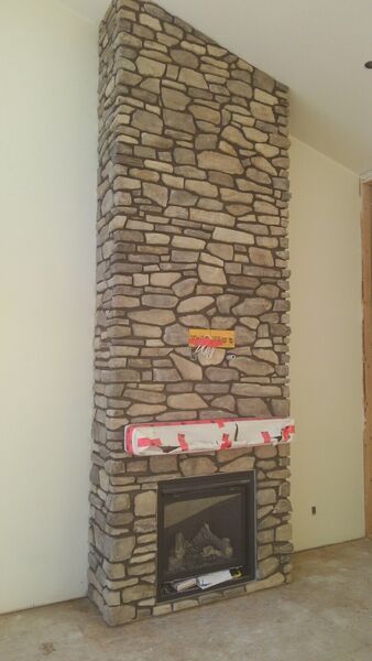 The same fireplace wall finished in natural stone to the ceiling